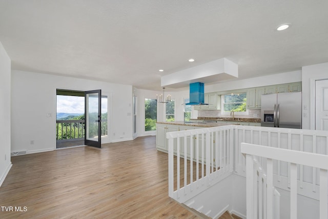 119 Orchard Meadows Ln, Roan Mountain, TN 37687 - kitchen with stainless steel refrigerator with ice dispenser, wall chimney exhaust hood, light wood-style floors, healthy amount of natural light, and recessed lighting