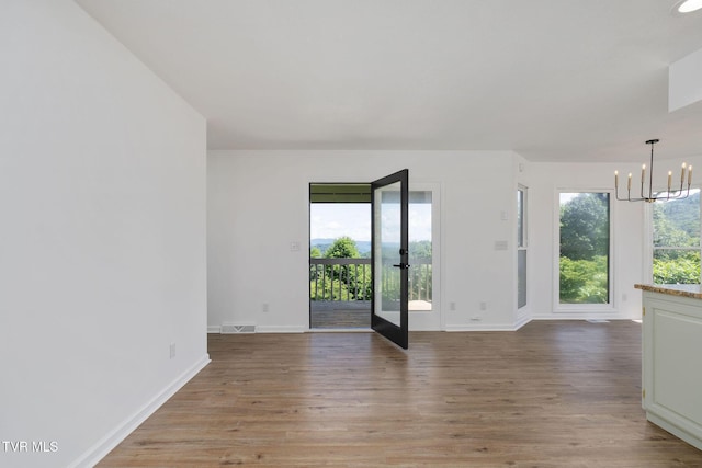 119 Orchard Meadows Ln, Roan Mountain, TN 37687 - spare room featuring a chandelier, light wood-style flooring, and french doors