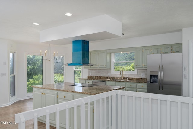 119 Orchard Meadows Ln, Roan Mountain, TN 37687 - kitchen with appliances with stainless steel finishes, wall chimney exhaust hood, a chandelier, tasteful backsplash, and light wood-style flooring