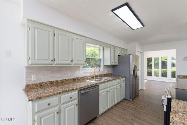 119 Orchard Meadows Ln, Roan Mountain, TN 37687 - kitchen featuring appliances with stainless steel finishes, light wood-style floors, decorative backsplash, white cabinets, and stone counters