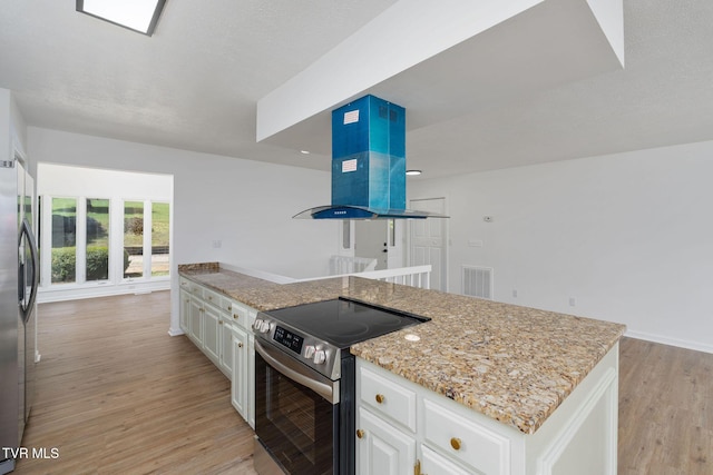 119 Orchard Meadows Ln, Roan Mountain, TN 37687 - kitchen featuring stainless steel appliances, light wood-style floors, light stone countertops, white cabinetry, and extractor fan