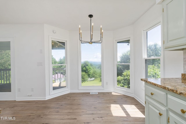 119 Orchard Meadows Ln, Roan Mountain, TN 37687 - unfurnished dining area featuring a chandelier, light wood-style floors, and plenty of natural light