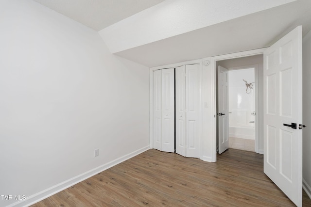 119 Orchard Meadows Ln, Roan Mountain, TN 37687 - unfurnished bedroom featuring light wood finished floors, lofted ceiling, and a closet