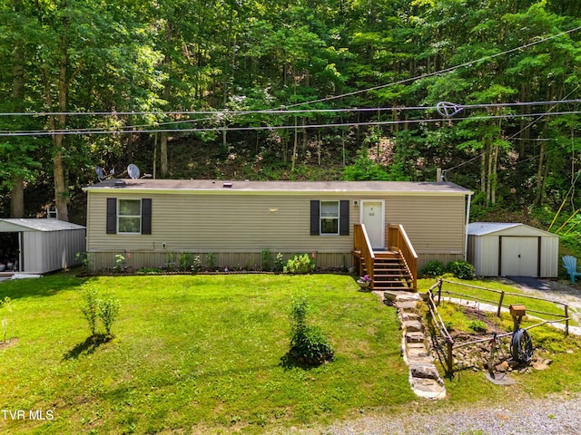 904 Briar Fork Rd, Bean Station, TN 37708 - manufactured / mobile home featuring a storage shed, a front lawn, a detached garage, and a forest view