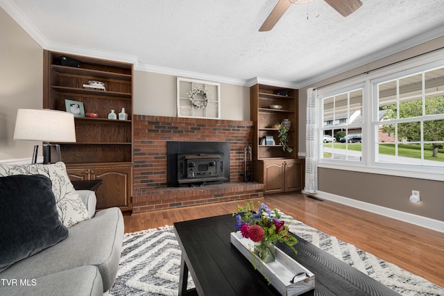 245 Highland Hills Dr, Gray, TN 37615 - living area featuring ceiling fan, a wood stove, a textured ceiling, wood finished floors, and ornamental molding
