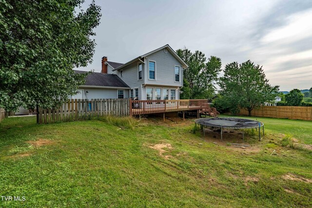 245 Highland Hills Dr, Gray, TN 37615 - rear view of property with a trampoline, a wooden deck, a fenced backyard, and a chimney