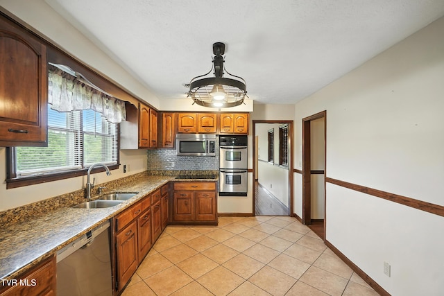 134 Richmond Hts, Jonesville, VA 24263 - kitchen with stainless steel appliances, backsplash, brown cabinetry, and light tile patterned flooring