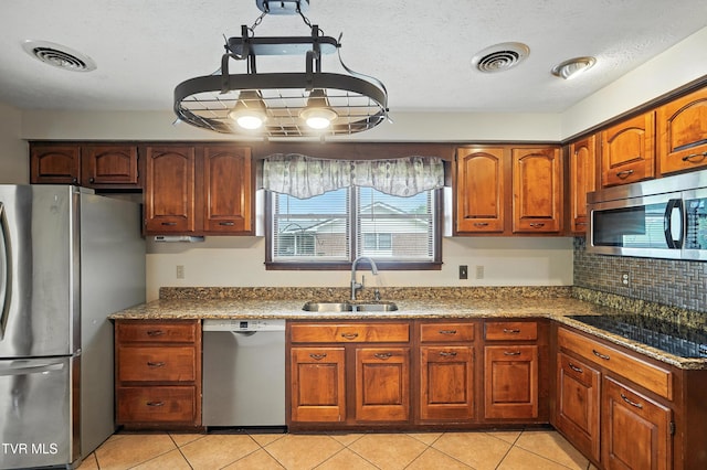 134 Richmond Hts, Jonesville, VA 24263 - kitchen with appliances with stainless steel finishes, light tile patterned floors, backsplash, light stone counters, and brown cabinets