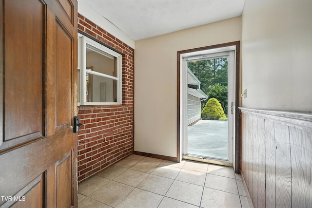 134 Richmond Hts, Jonesville, VA 24263 - doorway to outside featuring brick wall, light tile patterned floors, and wainscoting