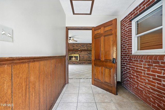 134 Richmond Hts, Jonesville, VA 24263 - hallway featuring brick wall, wainscoting, light tile patterned floors, and wood walls