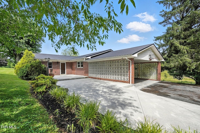 134 Richmond Hts, Jonesville, VA 24263 - ranch-style house featuring brick siding, driveway, a metal roof, an attached carport, and a front lawn