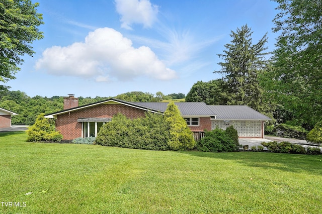 134 Richmond Hts, Jonesville, VA 24263 - view of front facade with brick siding, a chimney, a front yard, and a metal roof