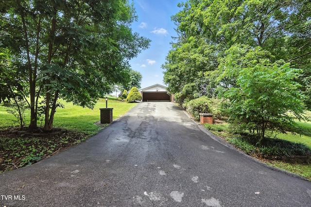 134 Richmond Hts, Jonesville, VA 24263 - obstructed view of property featuring a front lawn, a garage, driveway, and an outbuilding