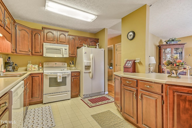 713 Teasel Dr Unit 0, Kingsport, TN 37660 - kitchen featuring white appliances, a textured ceiling, light countertops, light tile patterned floors, and brown cabinetry