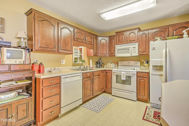 713 Teasel Dr Unit 0, Kingsport, TN 37660 - kitchen featuring white appliances, a textured ceiling, light countertops, light tile patterned floors, and brown cabinetry