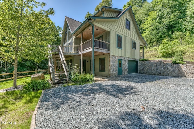 410 Eagle Ridge Rd, Roan Mountain, TN 37687 - view of front facade with stairs, board and batten siding, driveway, a garage, and a wooden deck