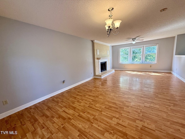 130 Kiser Cir, Jonesborough, TN 37659 - unfurnished living room featuring light wood-type flooring, a textured ceiling, a chandelier, a ceiling fan, and a fireplace