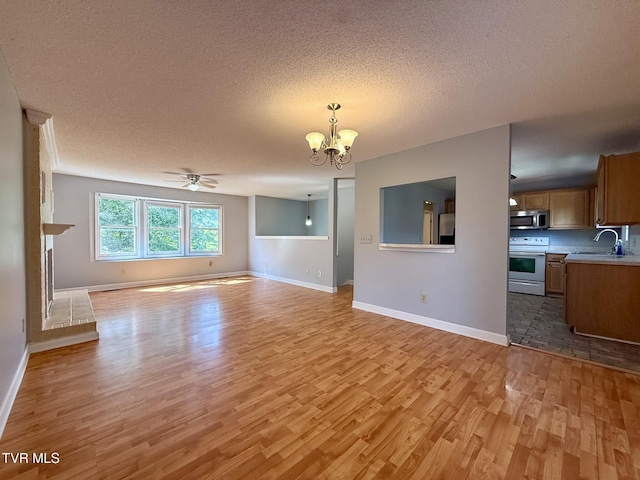 130 Kiser Cir, Jonesborough, TN 37659 - unfurnished living room with light wood-type flooring, a chandelier, a textured ceiling, and a ceiling fan