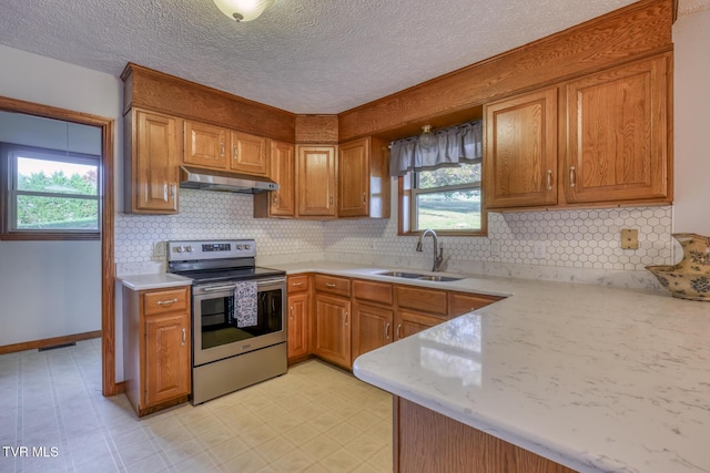 15060 Peaceful Valley Rd, Abingdon, VA 24210 - kitchen with stainless steel electric range oven, under cabinet range hood, plenty of natural light, brown cabinets, and a textured ceiling