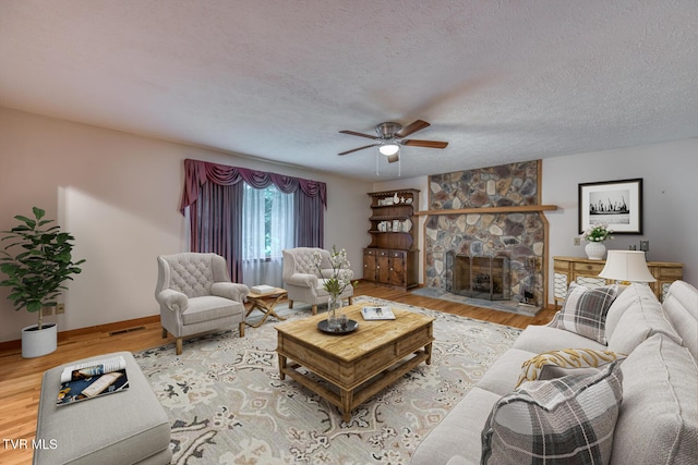 15060 Peaceful Valley Rd, Abingdon, VA 24210 - living room featuring ceiling fan, wood finished floors, a fireplace, and a textured ceiling