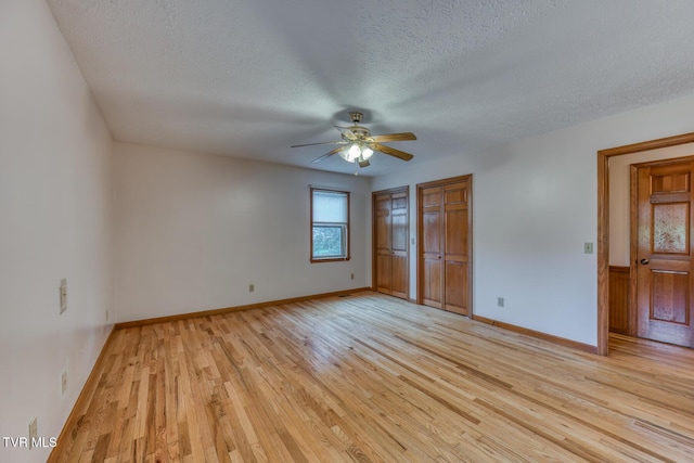 15060 Peaceful Valley Rd, Abingdon, VA 24210 - unfurnished bedroom featuring two closets, a textured ceiling, light wood finished floors, and a ceiling fan
