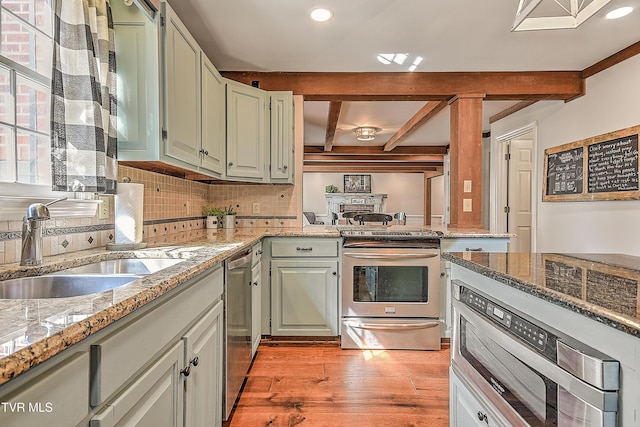 6054 Old Jonesboro Rd, Bristol, TN 37620 - kitchen with appliances with stainless steel finishes, light wood-type flooring, beam ceiling, decorative backsplash, and light stone countertops