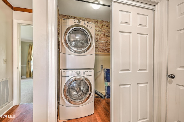 6054 Old Jonesboro Rd, Bristol, TN 37620 - laundry room featuring stacked washer / dryer, wood finished floors, and crown molding