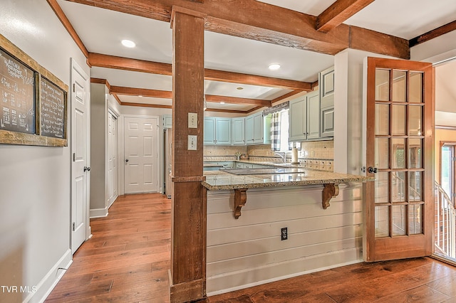 6054 Old Jonesboro Rd, Bristol, TN 37620 - kitchen with hardwood / wood-style floors, beamed ceiling, a kitchen breakfast bar, a peninsula, and decorative backsplash
