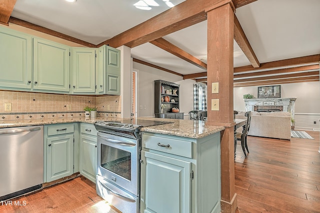 6054 Old Jonesboro Rd, Bristol, TN 37620 - kitchen featuring stainless steel appliances, beamed ceiling, open floor plan, a peninsula, and light wood-type flooring