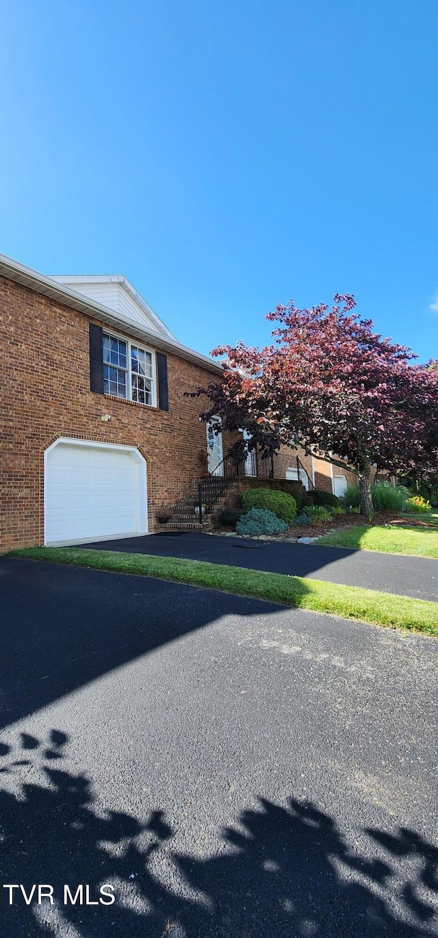 312 Old Franklin Pl Unit 5, Jonesborough, TN 37659 - view of side of home featuring a garage, asphalt driveway, and brick siding