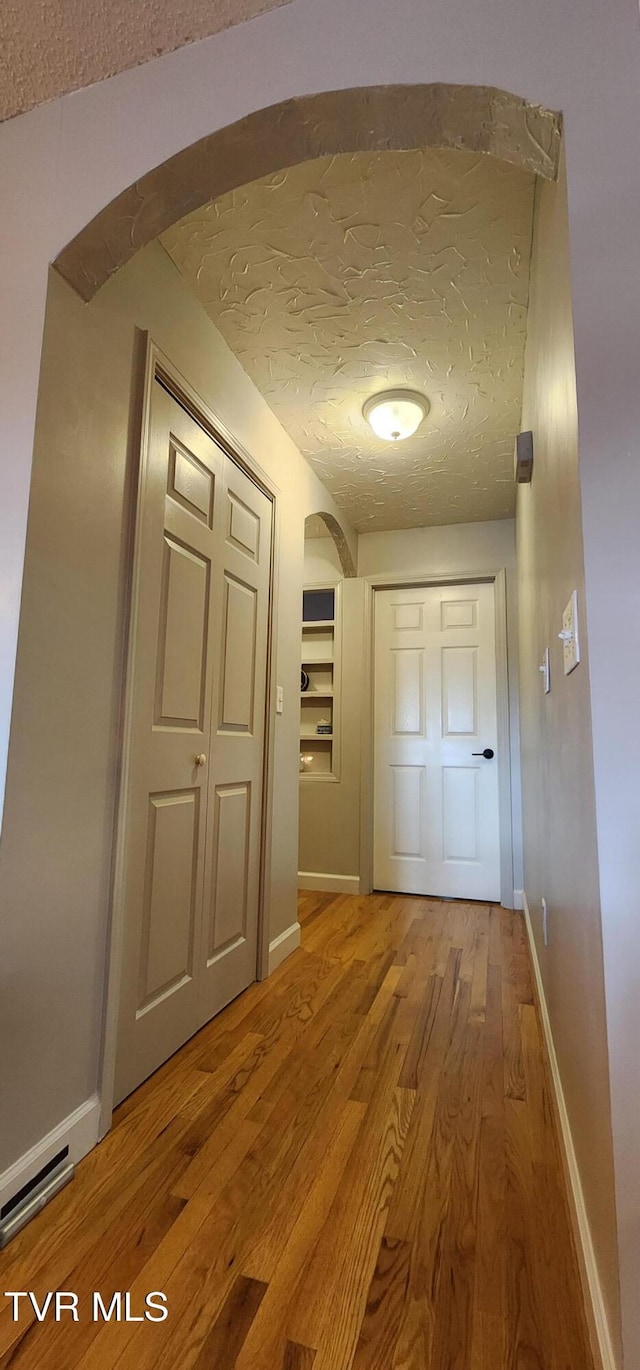 312 Old Franklin Pl Unit 5, Jonesborough, TN 37659 - hallway featuring light wood-style flooring, arched walkways, and a textured ceiling