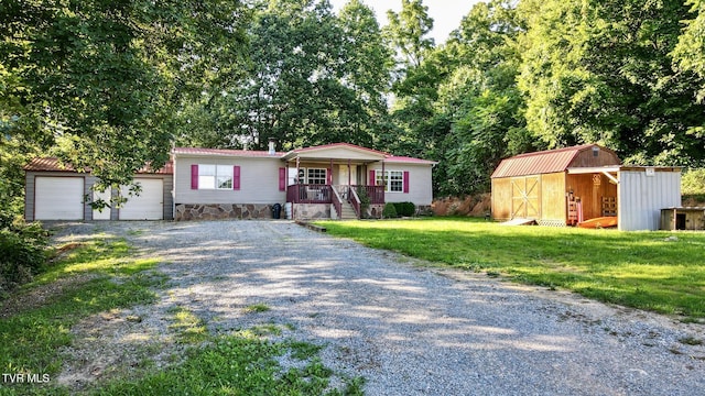 943 Newman Hollow Rd, Bean Station, TN 37708 - manufactured / mobile home with a porch, gravel driveway, a storage unit, and a front lawn