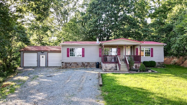 943 Newman Hollow Rd, Bean Station, TN 37708 - manufactured / mobile home with covered porch, gravel driveway, a front yard, a metal roof, and a garage
