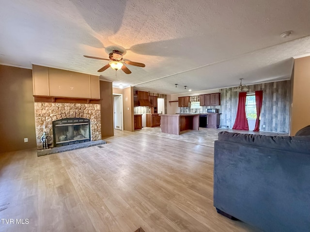 943 Newman Hollow Rd, Bean Station, TN 37708 - unfurnished living room featuring ceiling fan, a textured ceiling, light wood finished floors, and a fireplace