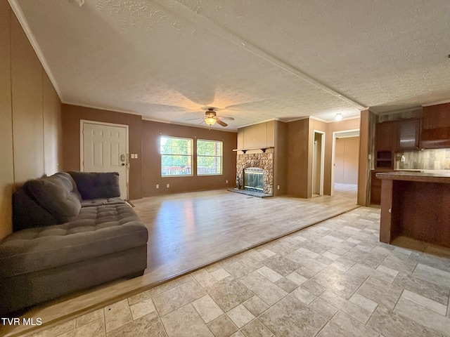 943 Newman Hollow Rd, Bean Station, TN 37708 - living room with a textured ceiling, ceiling fan, stone tile flooring, a stone fireplace, and crown molding