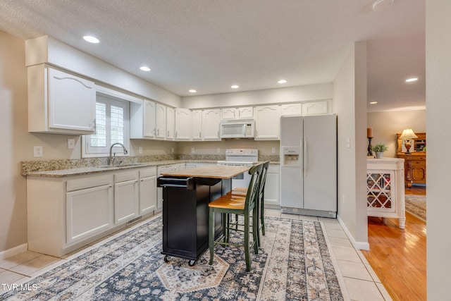 19275 Wyndale Rd, Abingdon, VA 24210 - kitchen with white appliances, white cabinetry, light tile patterned floors, recessed lighting, and a center island