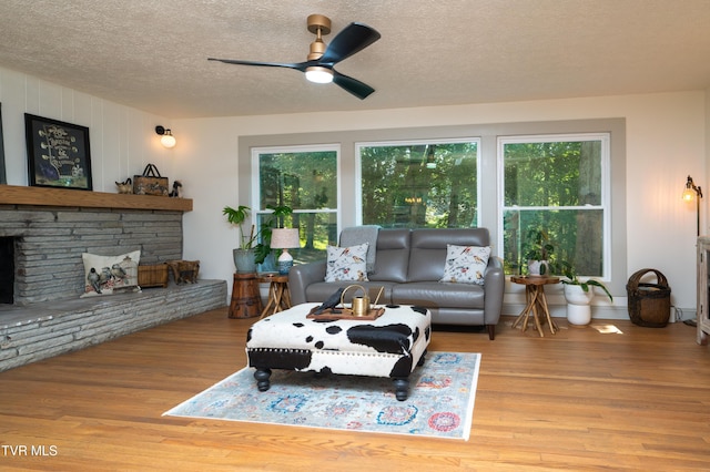 101 Ridgewood Dr, Bristol, TN 37620 - living area with plenty of natural light, wood finished floors, a textured ceiling, a ceiling fan, and a stone fireplace