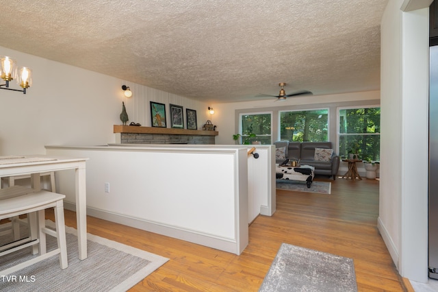 101 Ridgewood Dr, Bristol, TN 37620 - kitchen featuring a textured ceiling, ceiling fan, light wood-style flooring, and open floor plan