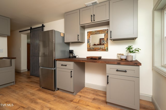 101 Ridgewood Dr, Bristol, TN 37620 - kitchen featuring wood counters, freestanding refrigerator, a barn door, gray cabinets, and light wood-type flooring