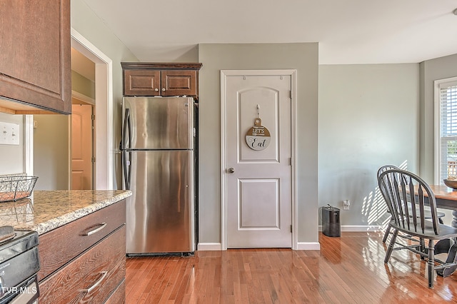 517 W Glade St, Glade Spring, VA 24340 - kitchen with freestanding refrigerator, light wood-style floors, light stone counters, and stove