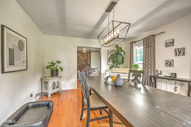 22643 Twin Oaks Rd, Abingdon, VA 24211 - dining space featuring wood finished floors, a textured ceiling, a barn door, and a chandelier
