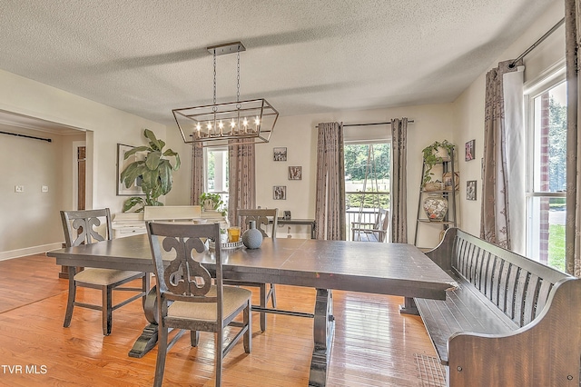 22643 Twin Oaks Rd, Abingdon, VA 24211 - dining area with light wood finished floors, a textured ceiling, and a chandelier