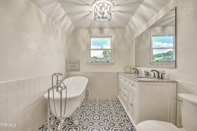 22643 Twin Oaks Rd, Abingdon, VA 24211 - full bathroom with tile walls, a wainscoted wall, vanity, a textured ceiling, and a freestanding bath