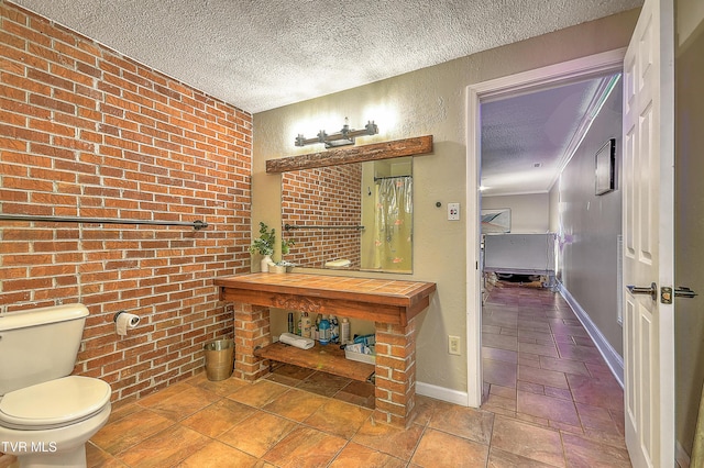 22643 Twin Oaks Rd, Abingdon, VA 24211 - bathroom featuring a textured ceiling, brick wall, and stone tile floors