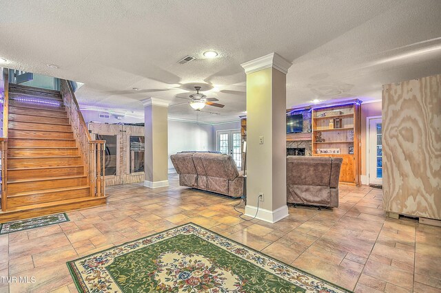 22643 Twin Oaks Rd, Abingdon, VA 24211 - living room with ornate columns, a textured ceiling, ceiling fan, stairs, and a fireplace