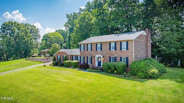 5116 Waterford Dr, Kingsport, TN 37664 - colonial-style house with a chimney, a front yard, and brick siding