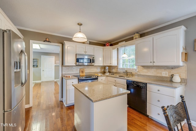5116 Waterford Dr, Kingsport, TN 37664 - kitchen featuring appliances with stainless steel finishes, white cabinets, hardwood / wood-style floors, tasteful backsplash, and ornamental molding