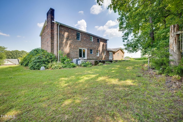5116 Waterford Dr, Kingsport, TN 37664 - back of house featuring a chimney, brick siding, and a yard