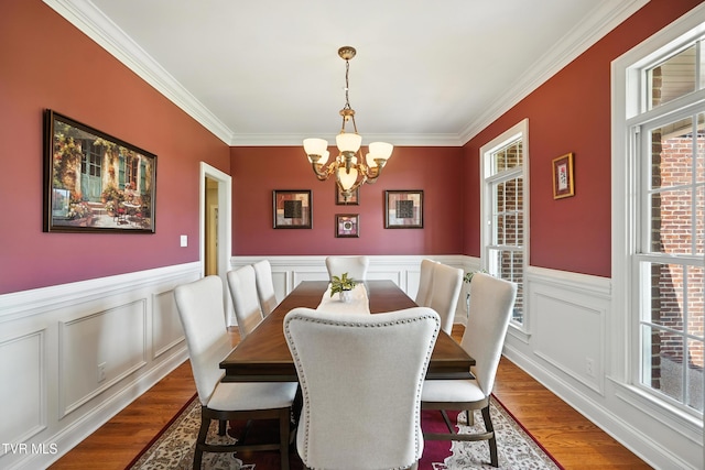 1251 Harmony Rd, Jonesborough, TN 37659 - dining space featuring a chandelier, crown molding, wood finished floors, wainscoting, and a decorative wall