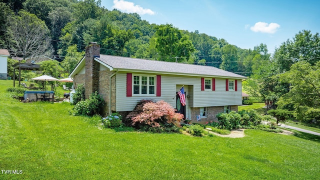 1049 Cooks Valley Rd, Kingsport, TN 37664 - split foyer home with a chimney, a front yard, a wooded view, and brick siding